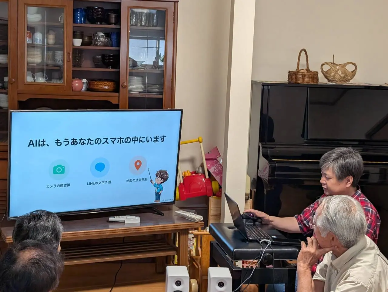 講師がノートパソコンを操作しながら、AIがすでにスマホの中で使われていることを解説している様子